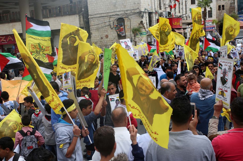 On April 23, 2017, in Nablus, West Bank, Palestinian protesters wave flags bearing the portrait of Marwan Barghouti during a demonstration in solidarity with Palestinian prisoners on hunger strike in Israeli jails.