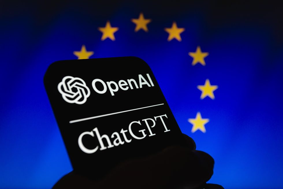 OpenAI logo and the name ''ChatGPT'' displayed on a smartphone backdropped by cropped flag of the European Union