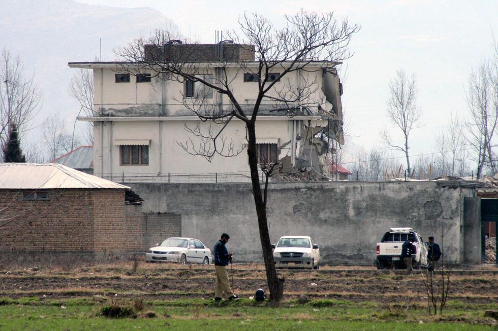 Pakistani police officers stand guard outside the compound of Osama bin Laden as authorities demolishing the house in northwest Pakistan's Abbottabad on Feb. 26, 2012.