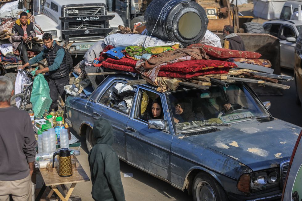 Palestinian families flee the city of Khan Yunis on the coastal road leading to Rafah amid the ongoing Israeli bombardment.