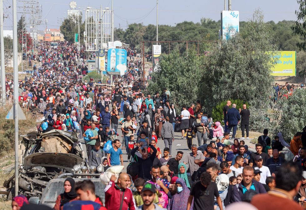Palestinian families fleeing Gaza City walk along a road towards the southern areas of the Gaza Strip.