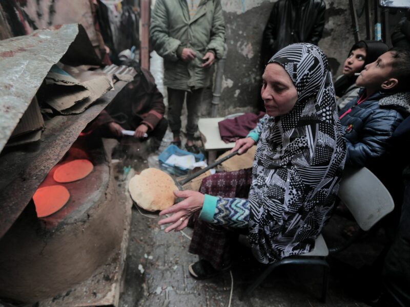 Palestinian woman makes bread in an old oven in the Al-Maghazi refugee camp in the central Gaza Strip.