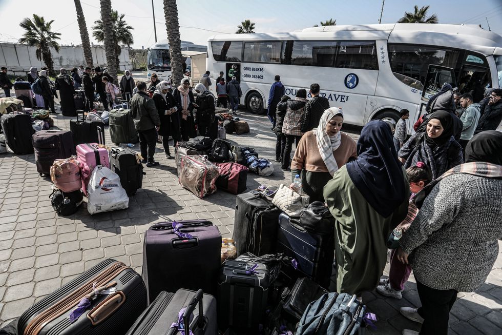 Palestinians, holding foreign passports, collect their luggage as they prepare to cross to Egypt from the Gaza Strip through the Rafah border crossing.