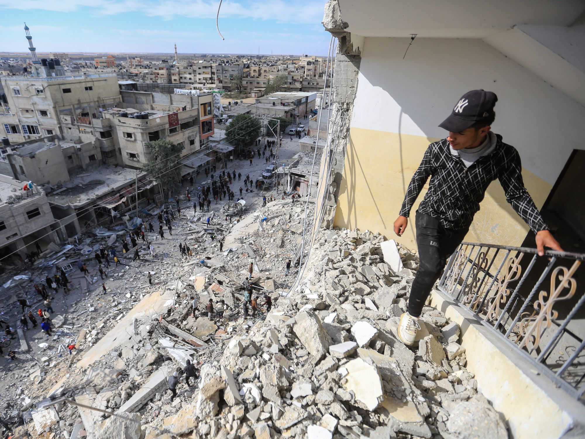 Palestinians inspect the massive damage caused by an Israeli air strike on Al-Masry Tower, downtown Rafah.