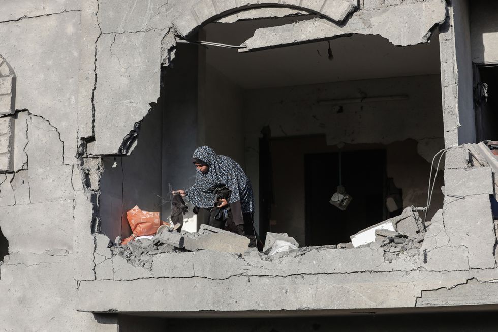 Palestinians inspect the rubble of a destroyed building after an airstrike by Israeli warplanes on the area in Deir al-Balah in the central Gaza Strip on December 22, 2024