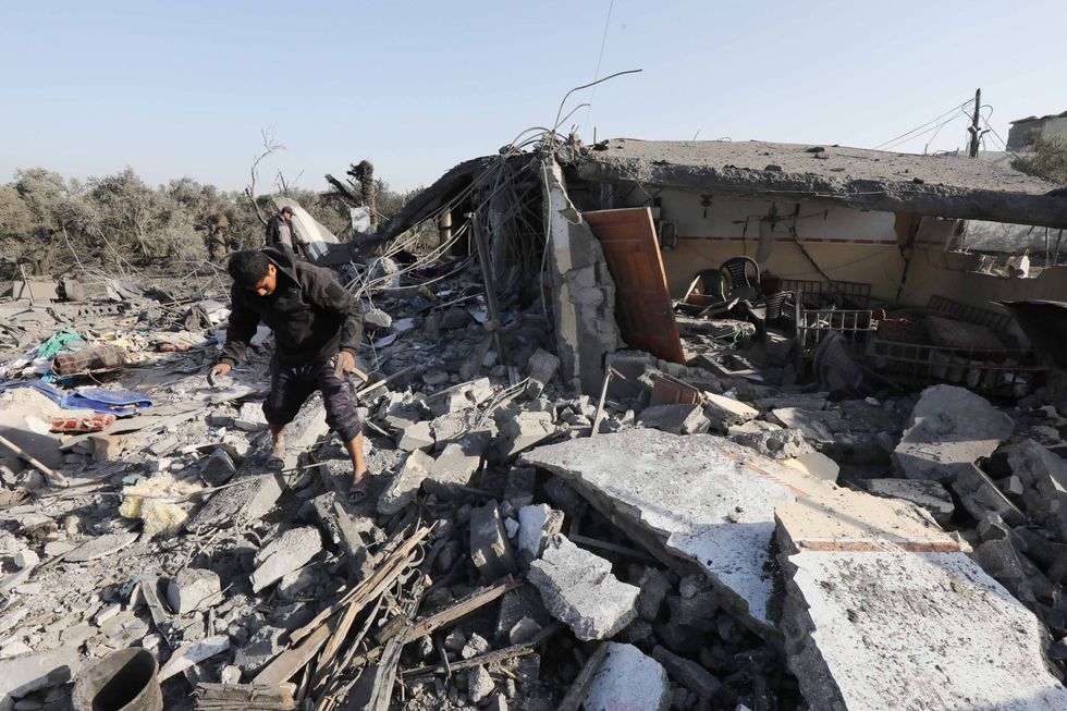 Palestinians search through rubble of Fleet family home that was destroyed during Israeli air strike on Dair El-Balah central of Gaza