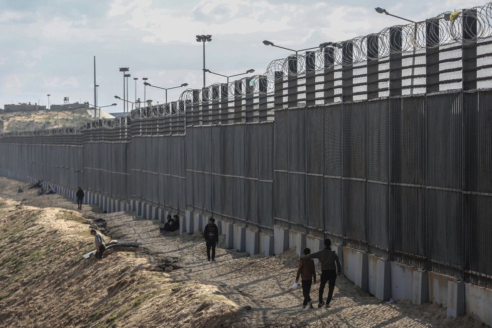 Palestinians stand near the Gaza-Egypt border​ of Rafah