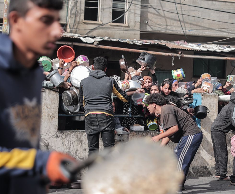 Palestinians wait to collect food at a donation point in a refugee camp in Rafah in the southern Gaza Strip.