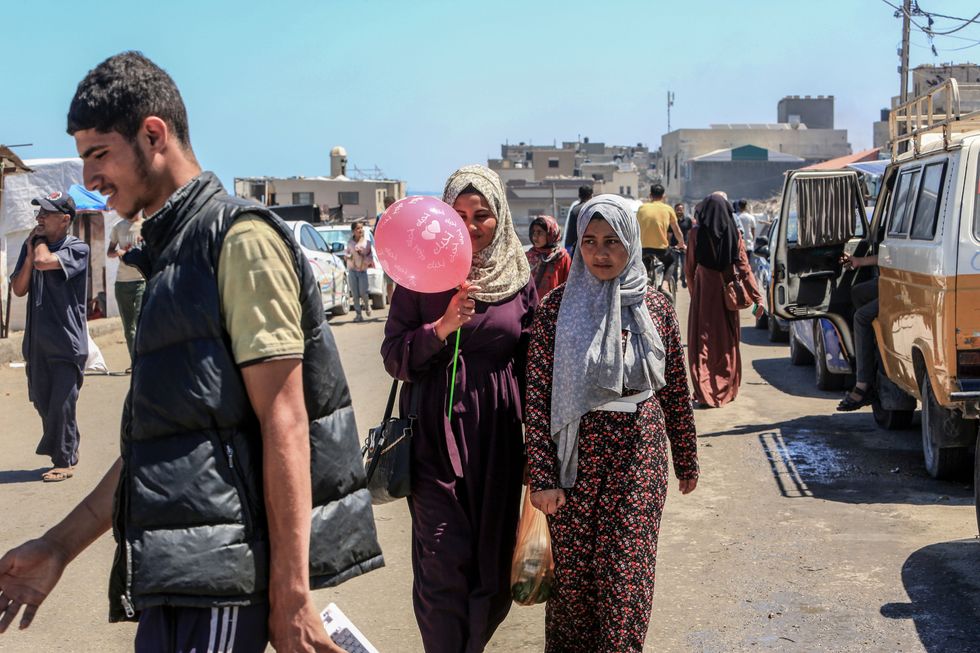 Palestinians walk on a street in Deir al-Balah in the central Gaza Strip.