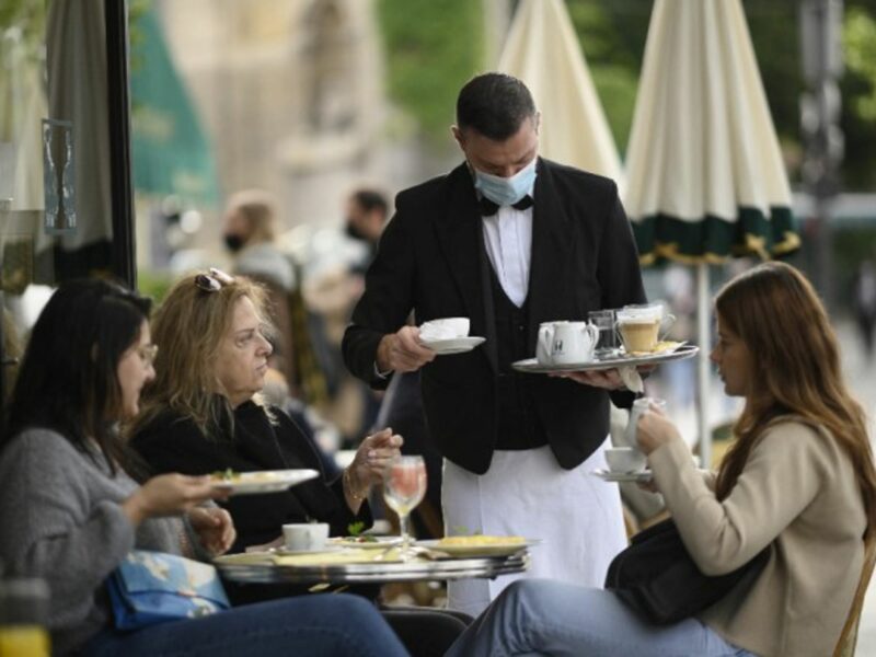 Parisians enjoy a coffee at an outdoor café on the first day of a partial reopening of economic and cultural activities after a near seven-month closure.