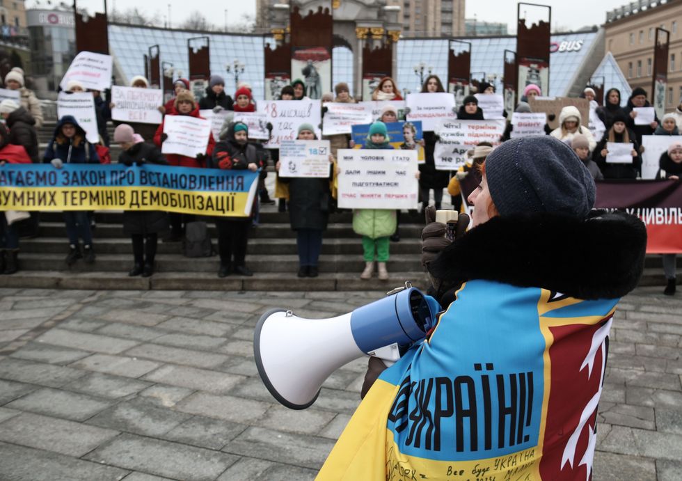Participants hold placards during a protest of military relatives who demand the demobilization of soldiers after 18 months of service on Maidan Nezalezhnosti Square, Kyiv, capital of Ukraine.