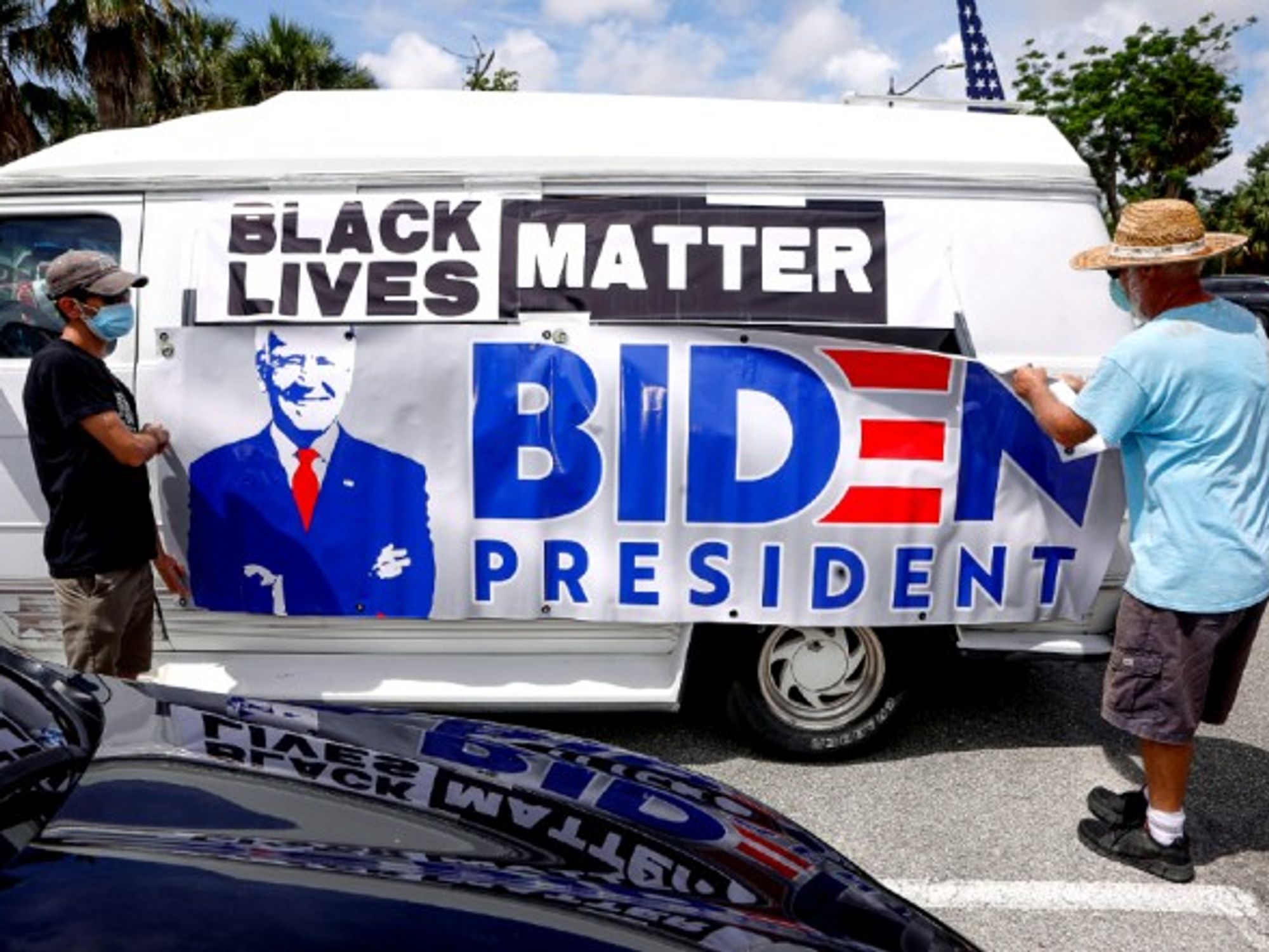 Participants in a BLM march attach a pro-Biden sign to their van in Palm Beach, FLA.