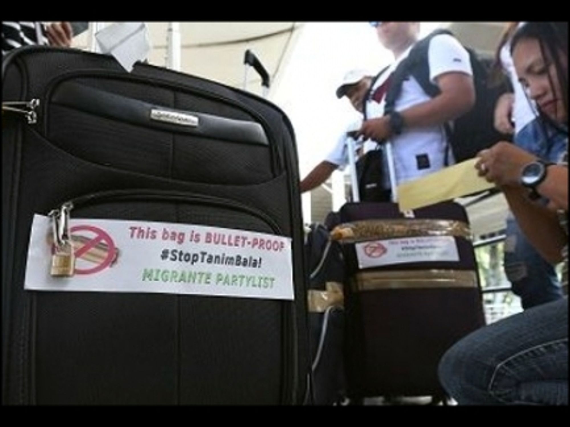 Passengers at Manila airport with anti-scam stickers.