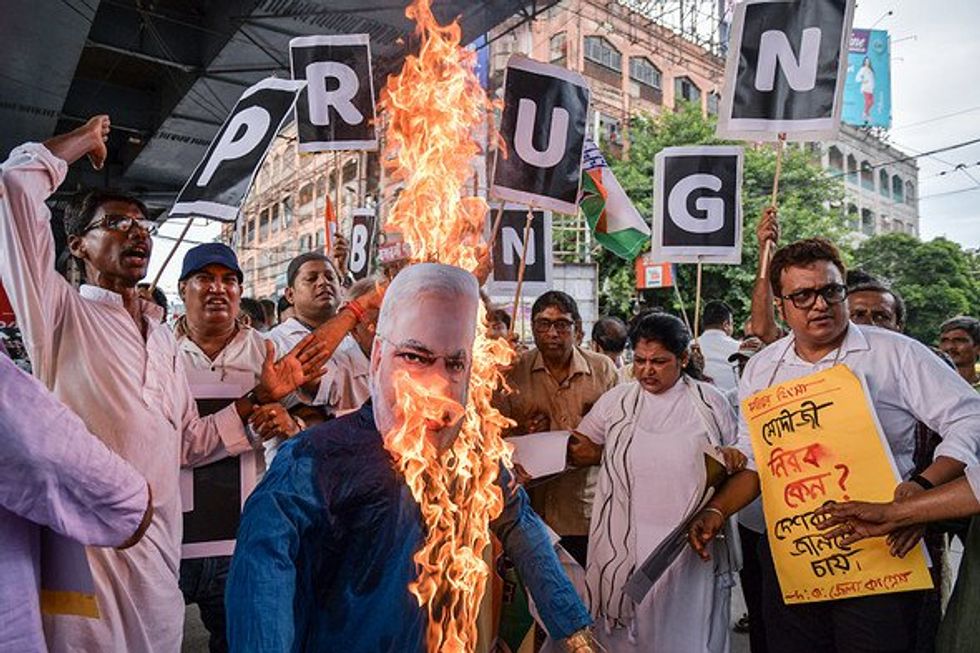 People burning effigy of India's Prime Minister Narendra Modi during a protest march.