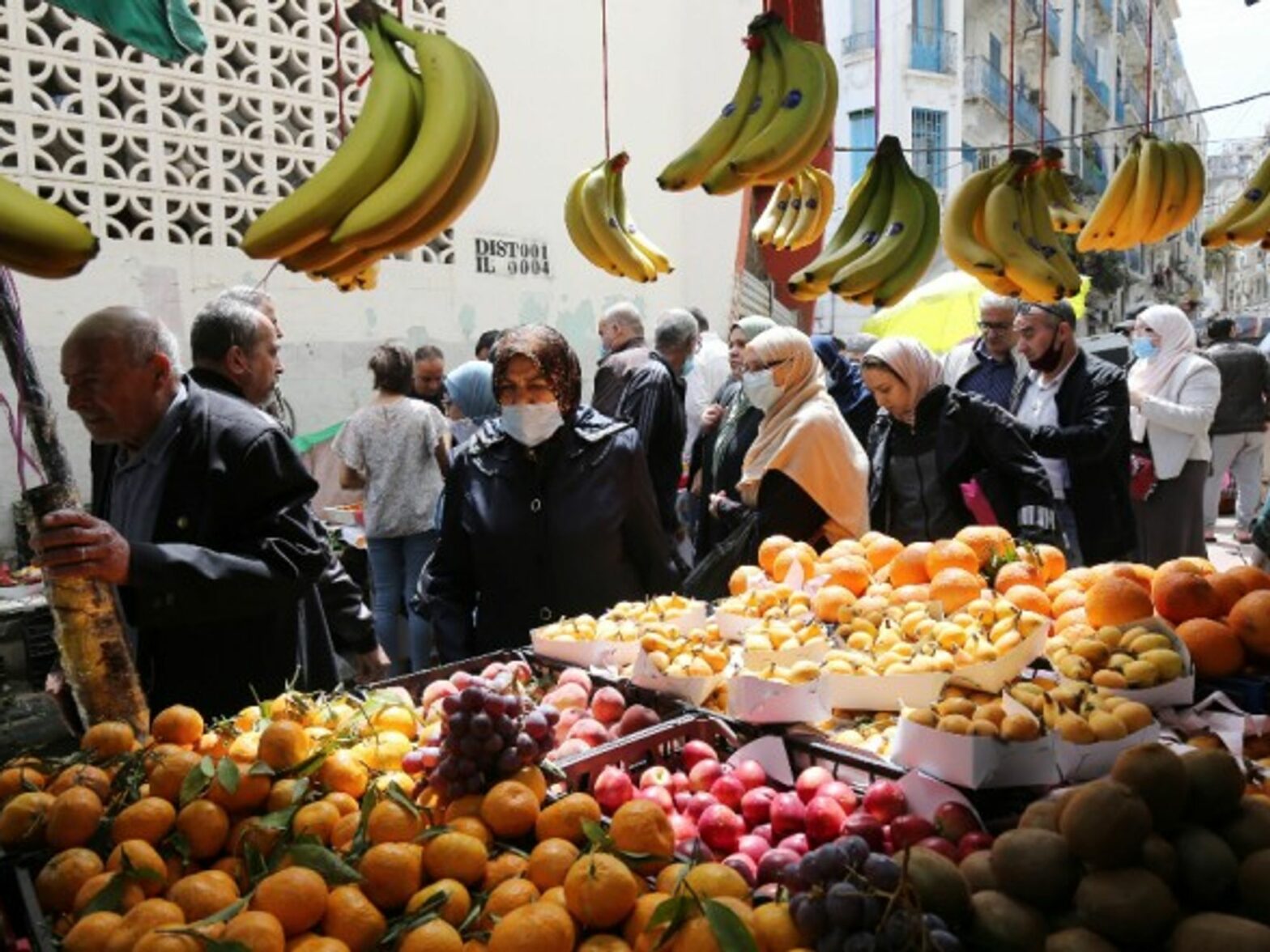 People buying food in a market on the first day of the month of Ramadan in Algiers