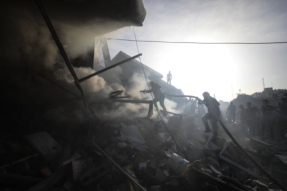 People conduct rescue work on a residential building destroyed in an Israeli strike in the southern Gaza Strip city of Khan Younis.