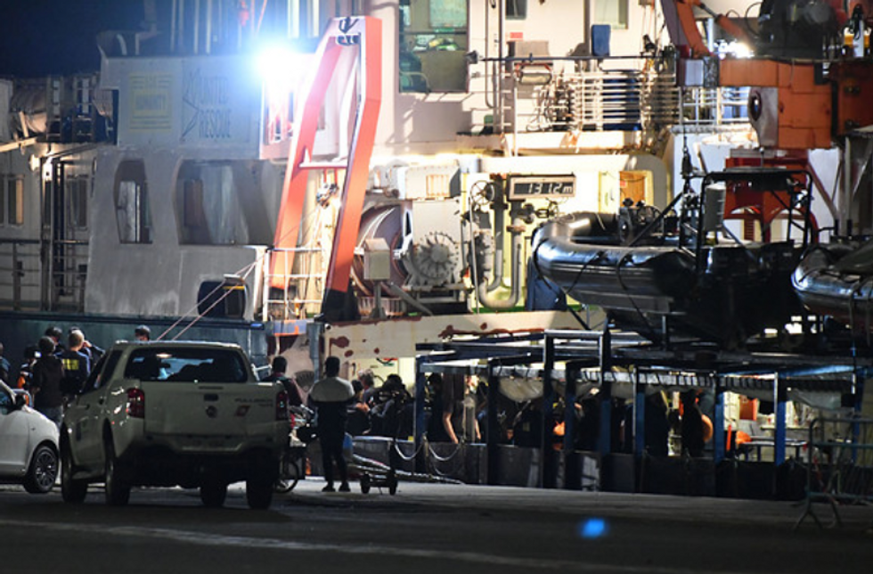 people disembarking from a boat at night