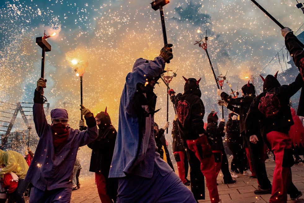 People dressed as devils make explode pyrotechnics during a correfoc on occasion of Nou Barris district festival in Barcelona.