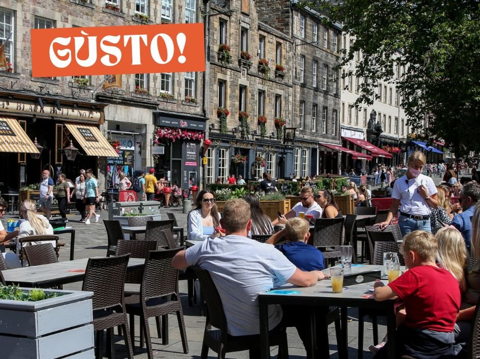 People eating outside in Edinburgh's Grassmarket.