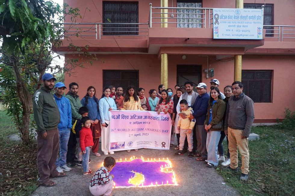 People from the Autism Care Nepal Society holding a banner.