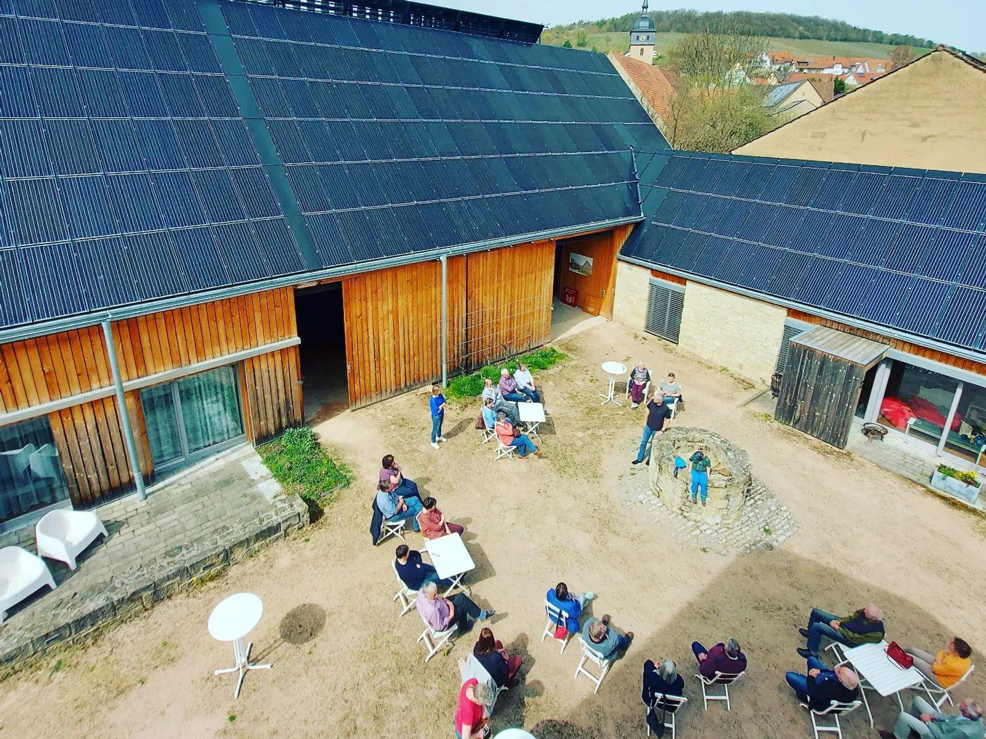 People gather in the garden of Hof 8, a self-sufficient home.