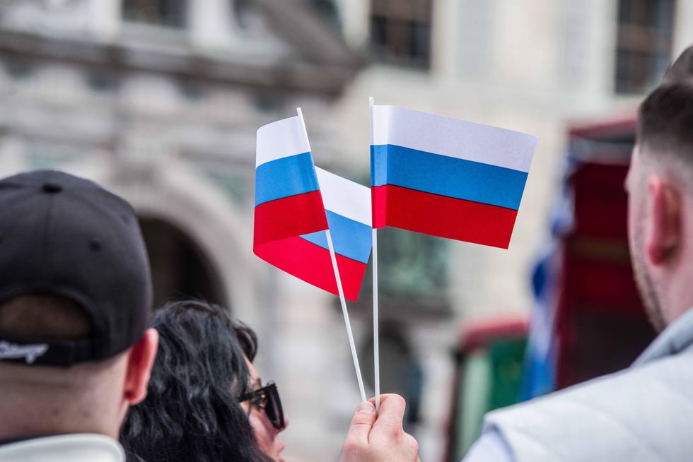 People holding a Russian flag during a celebration of Russian victory on May 9 in Munich