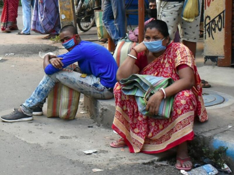 People in India wait for rice rations.