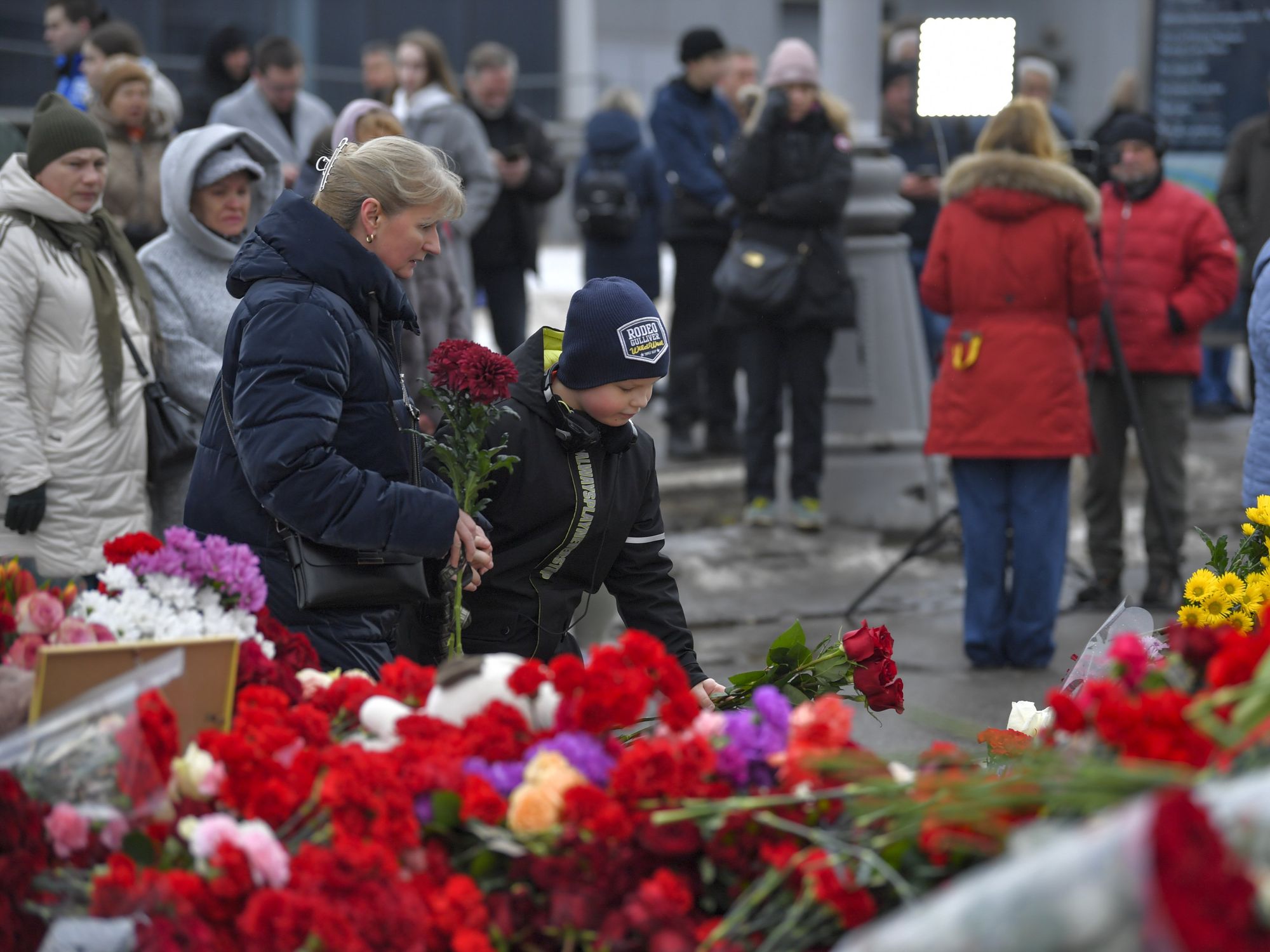 People lay flowers to mourn victims of a terrorist attack at the Crocus City Hall in Moscow, Russia, on March 22, 2024.