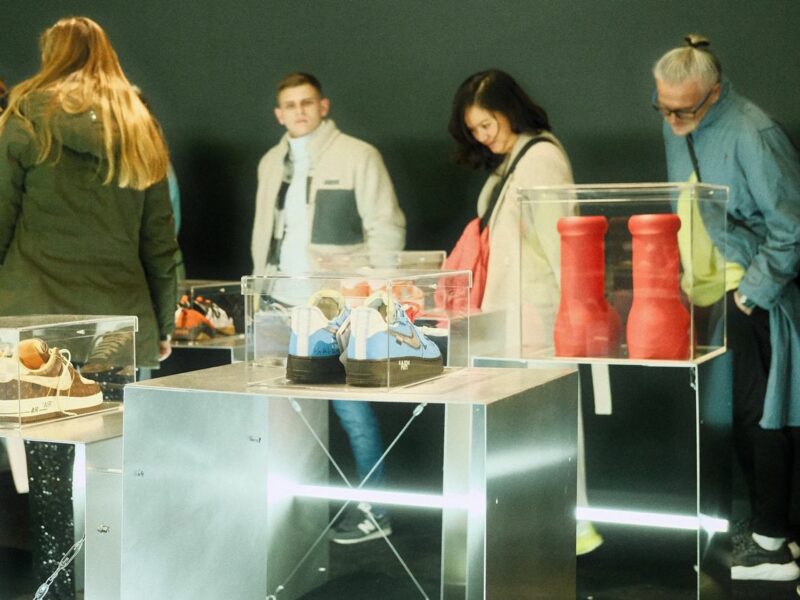 People look at an exhibition of a variety of sneakers.​