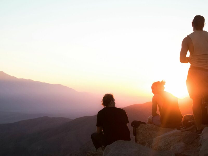 People on a mountain staring off into the distance.