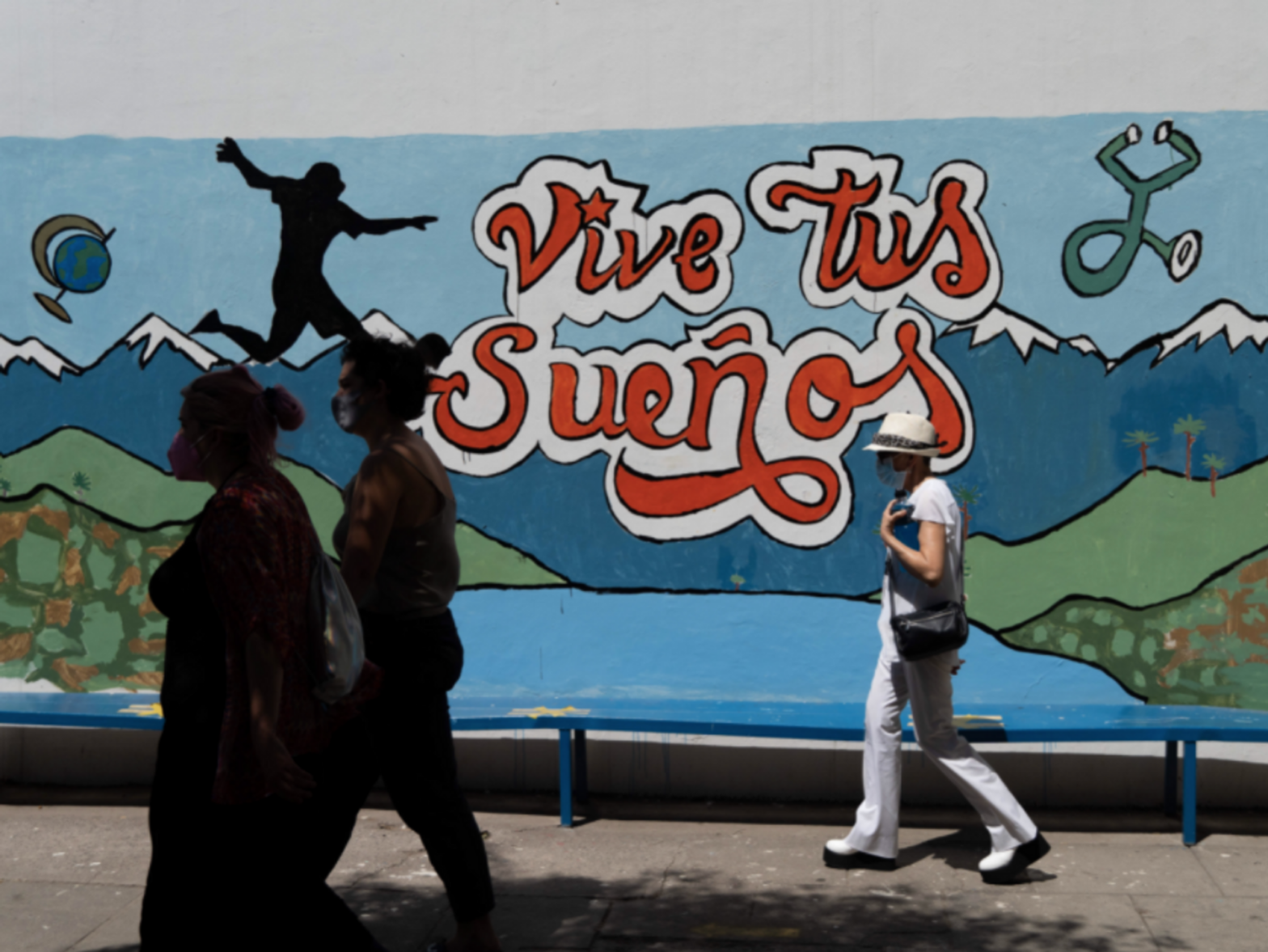 People pass in front of a mural that reads ''live your dreams'' in a polling place during the second round of the presidential elections in Santiago, Chile.