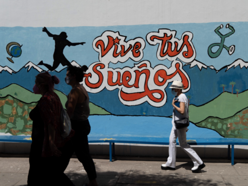 People pass in front of a mural that reads ''live your dreams'' in a polling place during the second round of the presidential elections in Santiago, Chile.
