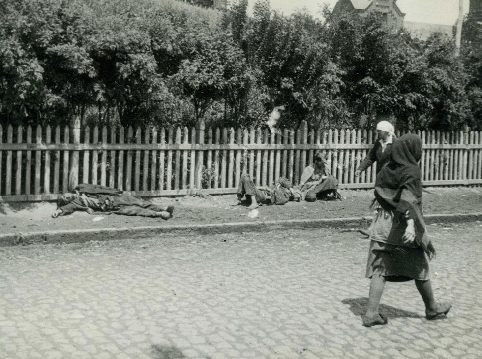 People passing by starved peasants on a street in Kharkiv during the famine in 1933