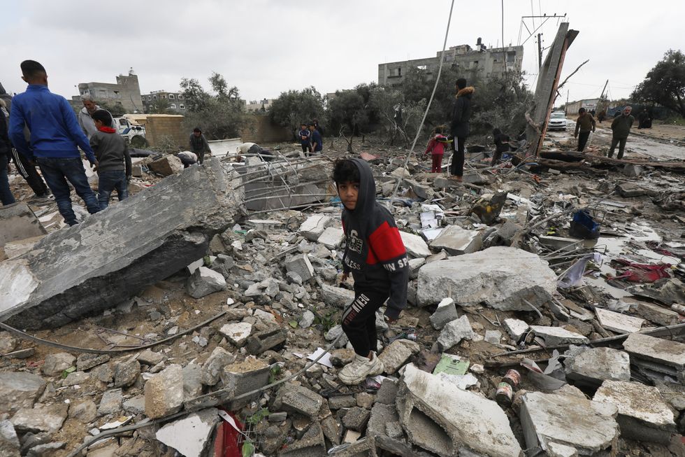 People recover items from their damaged homes on Tuesday following Israeli air strikes.