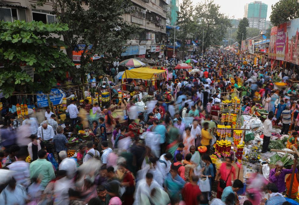 People shop at a crowded market place.