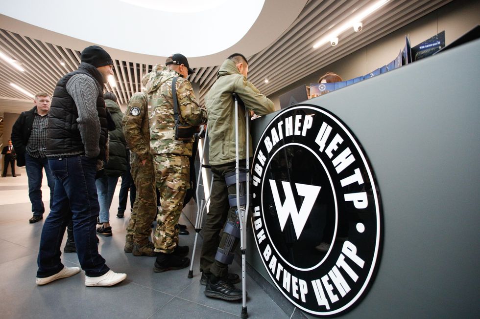 People, some wearing military outfits, in the lobby of the PMC Wagner Centre, inaugurated in November 2022.