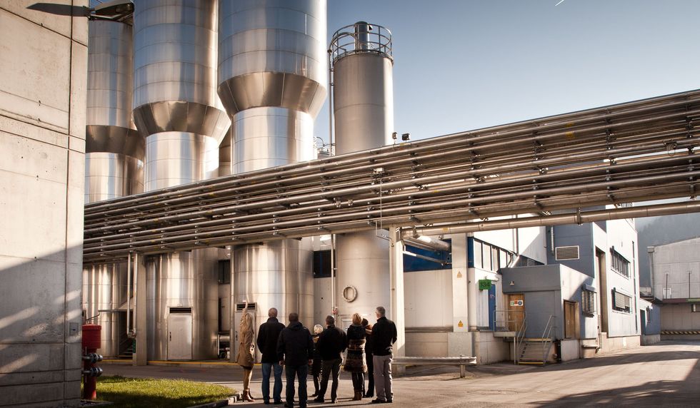 People standing in front of a factory.