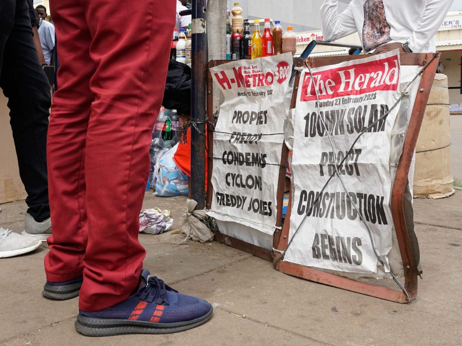 People standing in front of a vendor’s stall in Harare.
