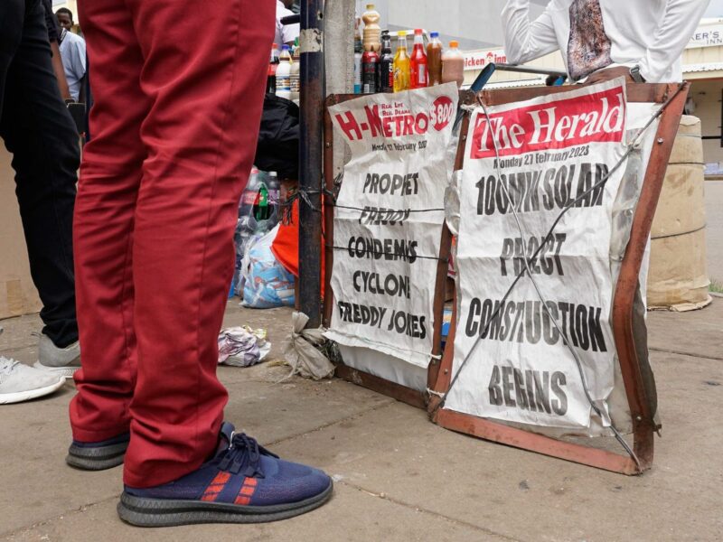 People standing in front of a vendor’s stall in Harare.