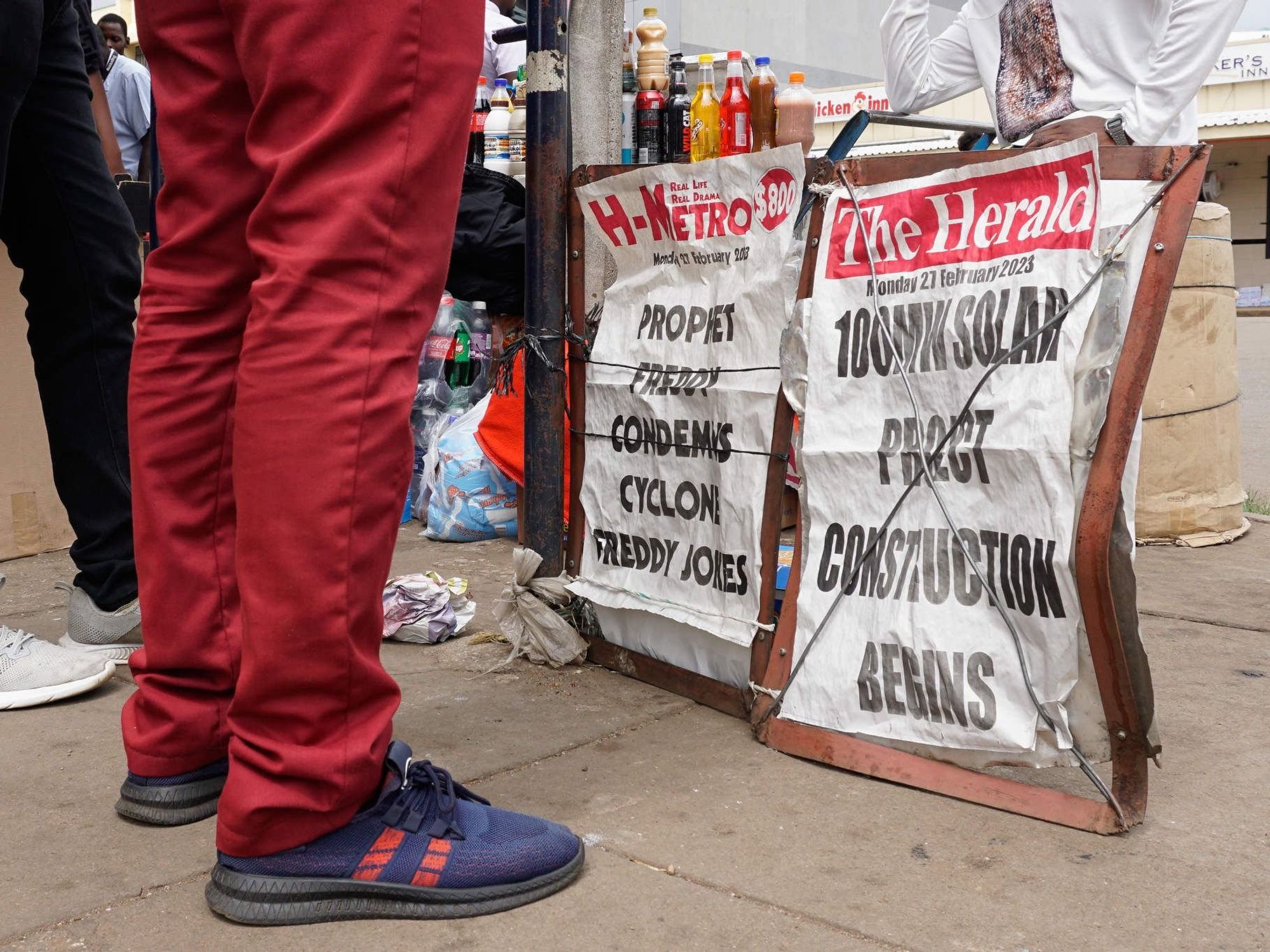People standing in front of a vendor’s stall in Harare.