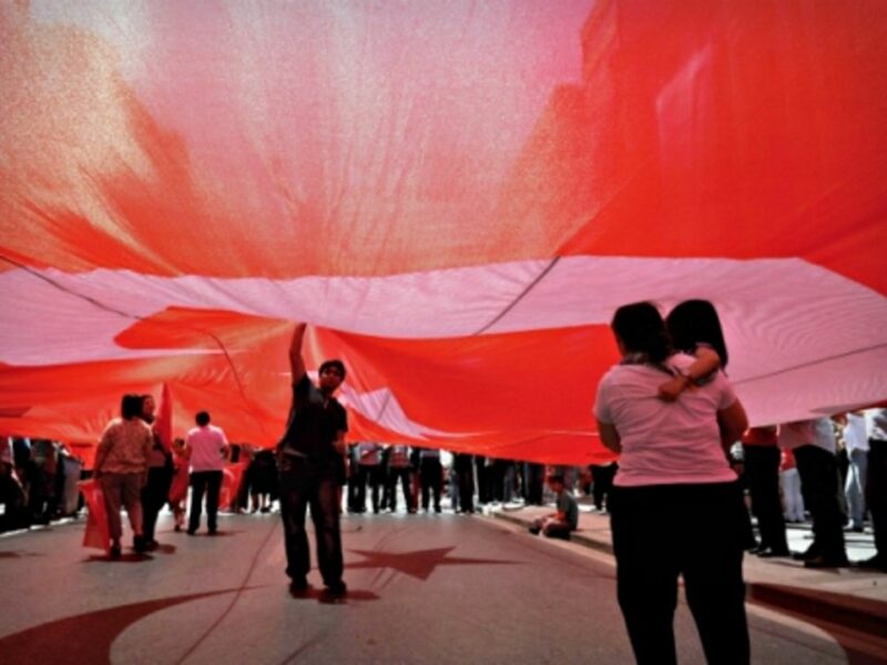 People under a giant Turkish flag in Istanbul