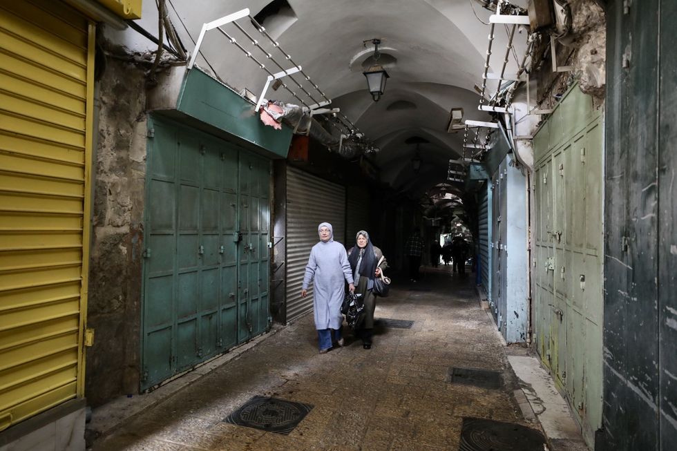 People walk past closed stores in Jerusalem's Old City.