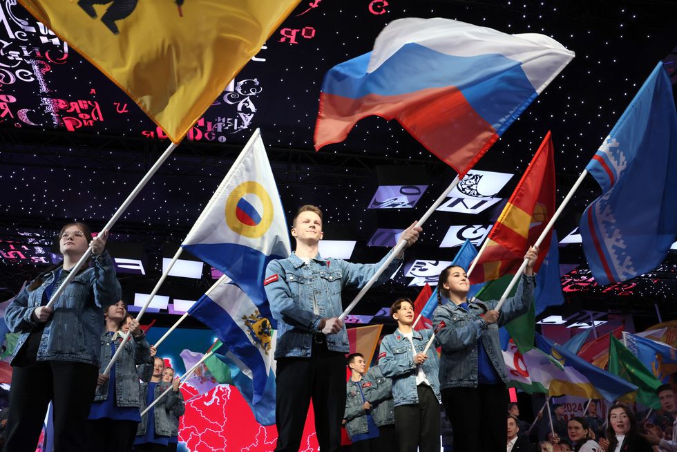 People wave flags during the second congress of the Russian movement of children and youth at the VDNKh exhibition centre