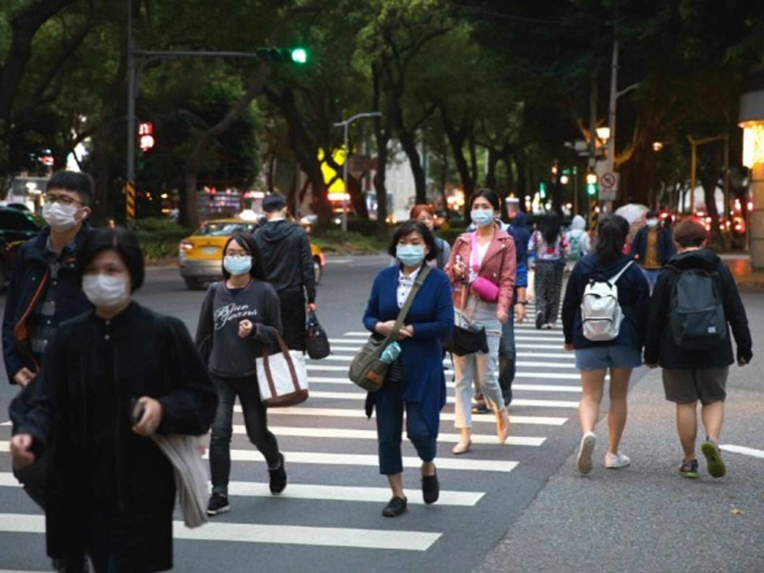 People wearing masks walk in the street in Taipei, Taiwan.