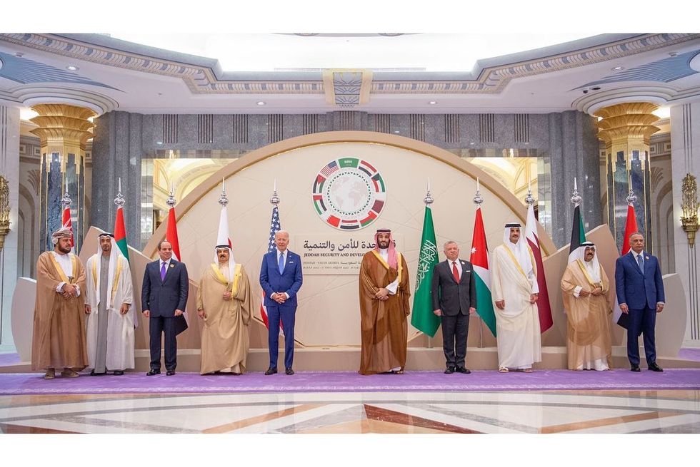 photo of 10 men in traditional arab clothes and western suits