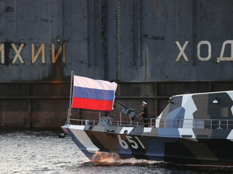 photo of a boat with a russian flag near a big