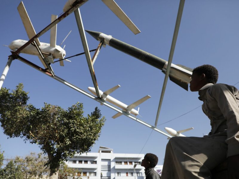 Photo of a boy looking at Mock Houthi-made drones and missiles
