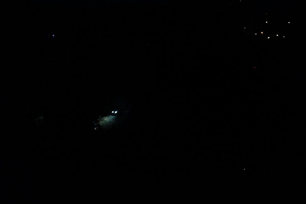 Photo of a car driving on a dark road