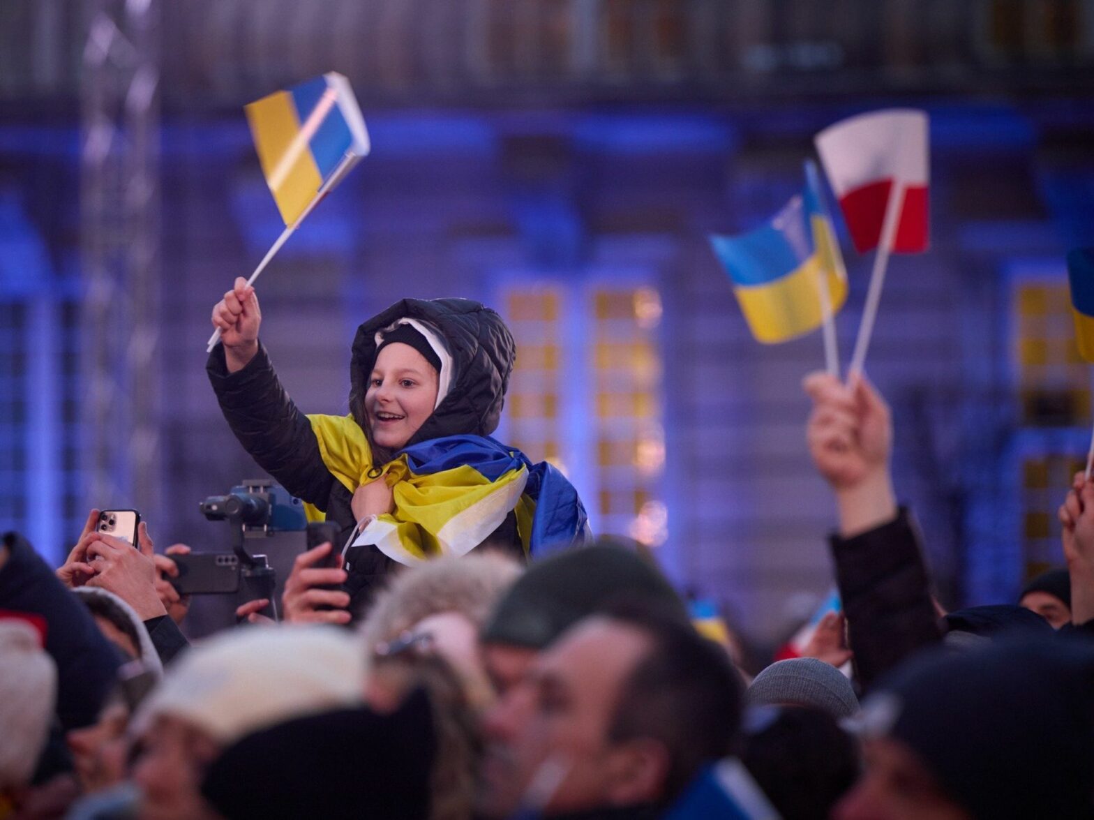 Photo of a child in a crowd waving Ukrainian and Polish flags during a speech by Volodymyr Zelensky in Warsaw on April 6