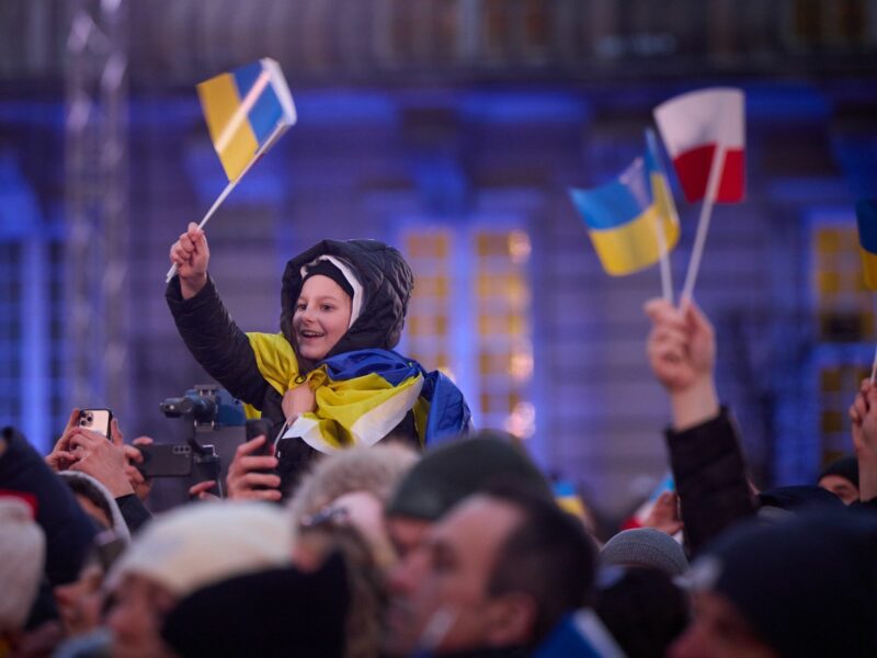 Photo of a child in a crowd waving Ukrainian and Polish flags during a speech by Volodymyr Zelensky in Warsaw on April 6
